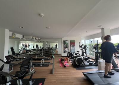 Gym with various exercise equipment and people working out