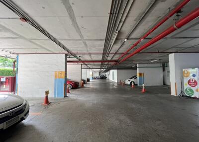 Parking area in a building with multiple cars and safety cones