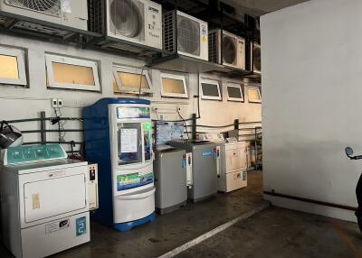 Laundry room with multiple washing machines and air conditioning units