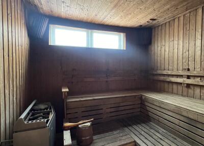 Wood-paneled sauna with benches and heater