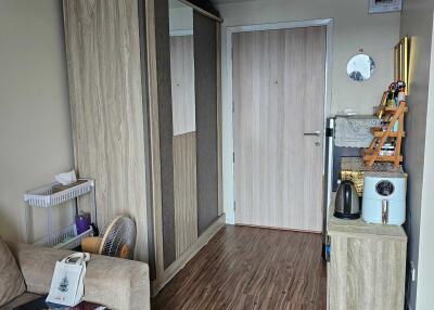 Living space with wooden flooring, wardrobe, and a small kitchenette