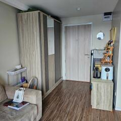 Living space with wooden flooring, wardrobe, and a small kitchenette