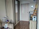 Living space with wooden flooring, wardrobe, and a small kitchenette