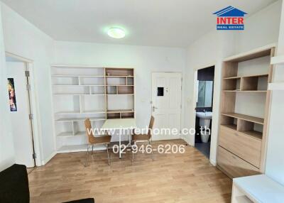 Bright and cozy main living space with wooden floors, built-in shelving, and ample natural light
