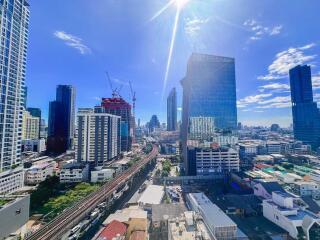 Aerial view of a city with high-rise buildings and construction cranes