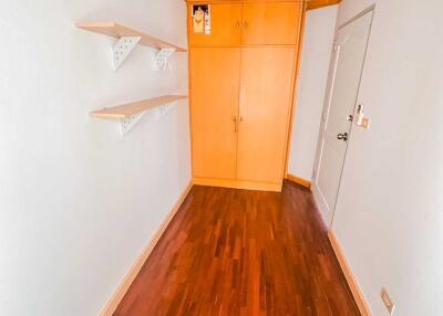 hallway with wooden flooring, shelves, and cabinet