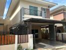 Two-story modern house with balcony and carport