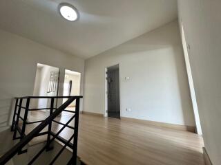 Second-floor hallway with wooden flooring and modern railing