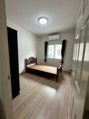 Simple bedroom with wooden bed frame and window