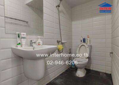 Modern bathroom with white tiles, sink, mirror, toilet and shower