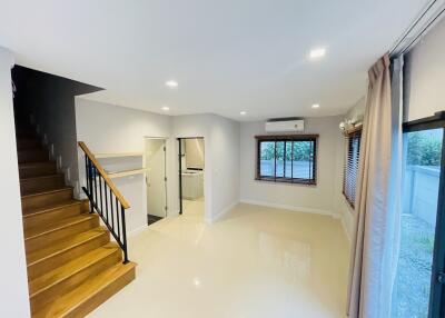 Spacious living room with wooden staircase and large windows