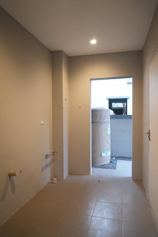 A empty utility room with a doorway leading outside