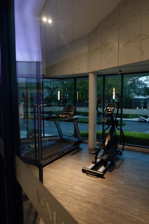 Home gym with exercise equipment and large windows
