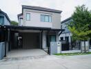 Front view of a modern two-story house with a driveway and small lawn