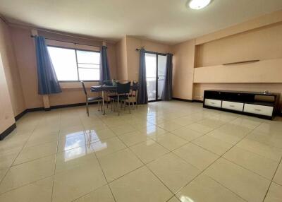 Spacious living room with large windows, tiled floor and dining area