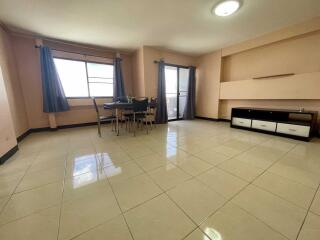 Spacious living room with large windows, tiled floor and dining area