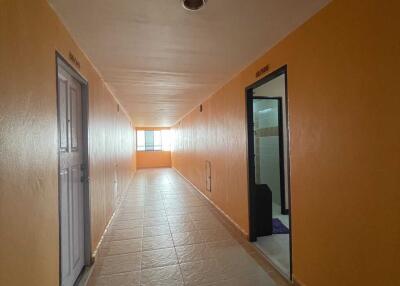 A hallway with tiled flooring and brightly painted walls