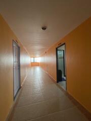 A hallway with tiled flooring and brightly painted walls