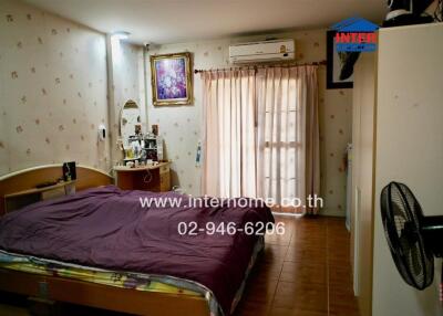 Bedroom with bed, vanity, and AC unit.