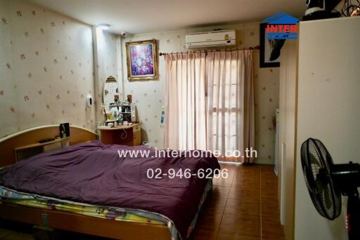 Bedroom with bed, vanity, and AC unit.