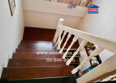 Staircase with wooden steps and white railing