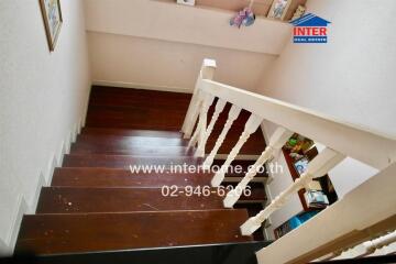 Staircase with wooden steps and white railing