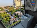 Apartment balcony with washing machine and view of surrounding buildings
