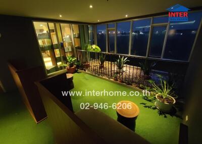Night-time view of a balcony with potted plants and furniture