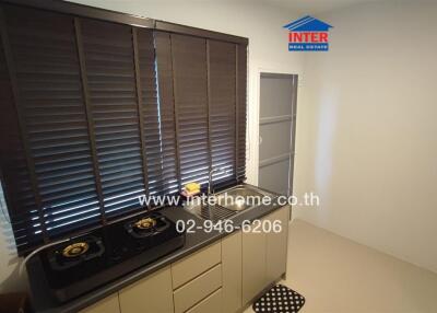 Small kitchen space with stove and window blinds