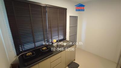 Small kitchen space with stove and window blinds