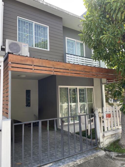 Front view of a modern two-story house with a covered carport and balcony