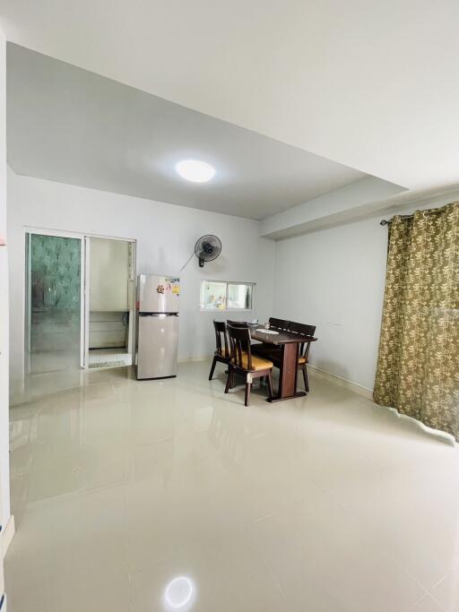 Bright dining area with a table and chairs, near a small kitchen