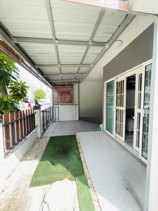 Covered outdoor space with tiled flooring and sliding glass doors