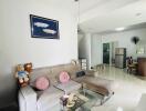 Modern living room with a sofa, ceiling fan, and glass coffee table