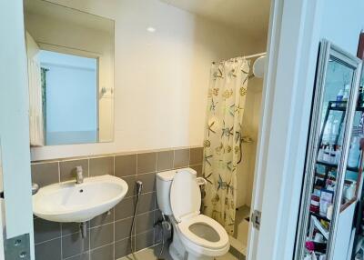 Bathroom with sink, toilet, mirror, and shower