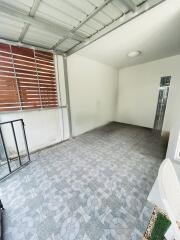 Covered patio area with tiled flooring and window slats