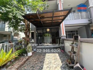 Front view of a house with a small garden and covered porch