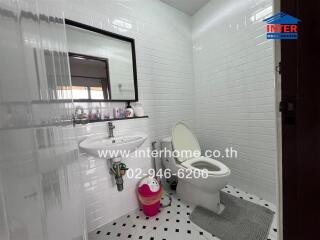 Modern bathroom with white subway tiles and a mirror above the sink