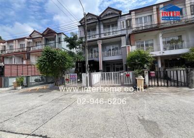 Front view of a residential building with multiple floors and gated entrances