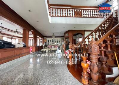 Spacious living area with staircase and ornate wooden details