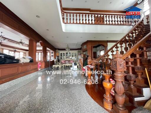 Spacious living area with staircase and ornate wooden details