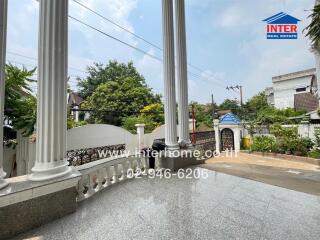 Front outdoor view of residential property with columns and gate