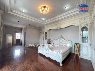 Spacious bedroom with vintage white furniture and wooden flooring