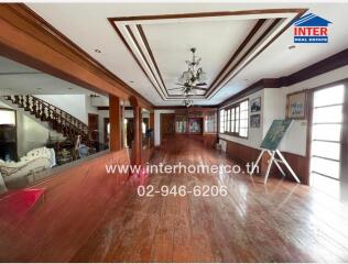 Spacious living room with hardwood floors and decorative ceiling