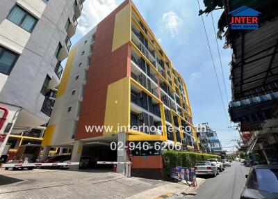 Exterior view of an apartment building with a yellow and brown facade