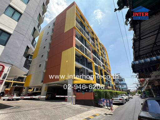 Exterior view of an apartment building with a yellow and brown facade