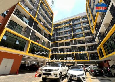 Exterior view of an apartment building with a parking lot