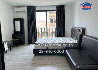 Bedroom with a large bed, sofa, vanity table, and balcony view