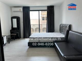 Bedroom with a large bed, sofa, vanity table, and balcony view