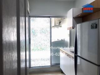 Compact kitchen area with modern appliances and large frosted glass window